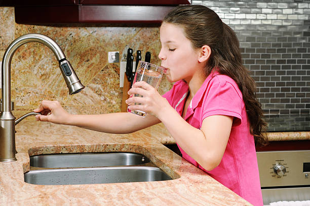 Girl drinking a glass of water.